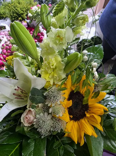 Sommerstrauß mit Sonnenblume, weißen Lilien und Löwenmäulchen