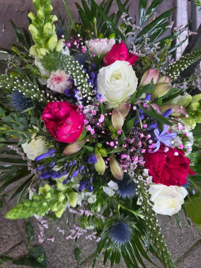 Üppiger Strauß mit pinker Pfingstrose, weißen Rosen und blauen Edeldisteln