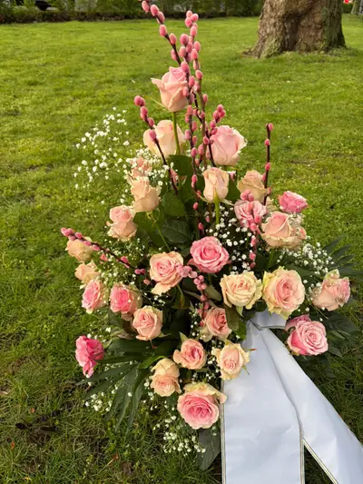 Trauergesteck mit rosa Rosen und Weidenkätzchen